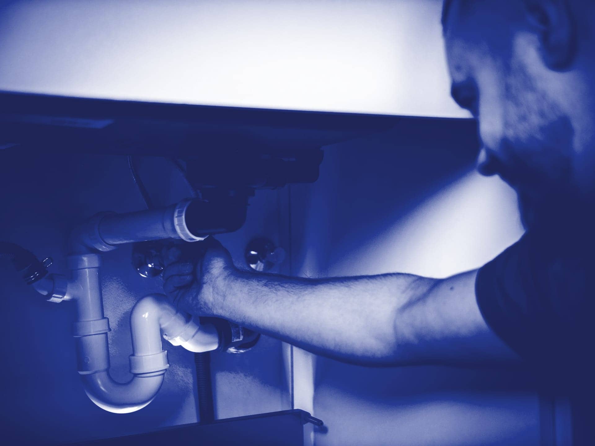 Plombier qui resserre le siphon d’un lavabo